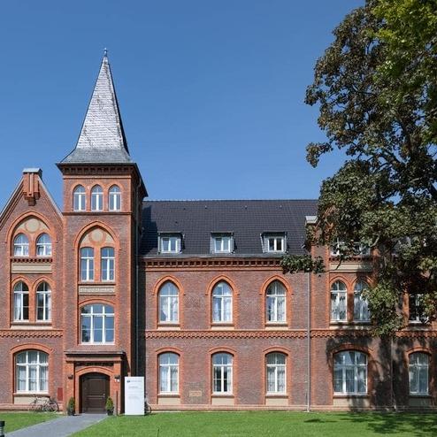 Eingang mit Turm der Sozialimmobilie Demenzzentrum in Ratingen mit brauner Klinkerfassade