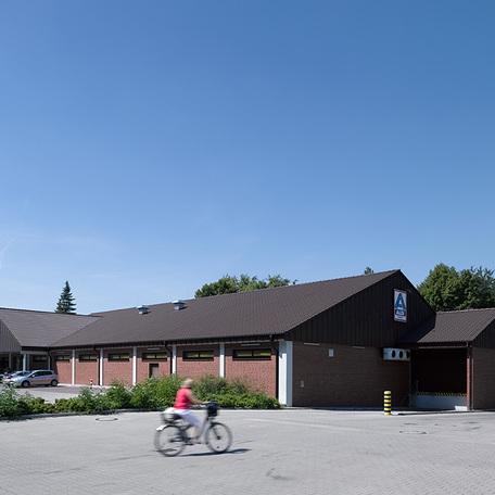 Gebaeudeansicht des Fachmarktzentrum in Recklinghausen von aussen mit Klinkerfassade, Aldi Logo und Parkplaetzen