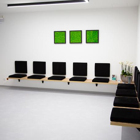 Wartezimmer der Zahnarztpraxis des Gewerbegebaeude Kraemer in Wuppertal mit weissen Waenden, dezenter Deko und Sitzmoeglichkeiten