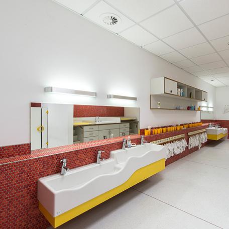 Badezimmer mit Waschbecken, Spiegeln, Moebeln, Handtuechern und Zahnbursten mit Bechern fuer die Kindergartenkinder der Kindertagesstaette in Wuppertal