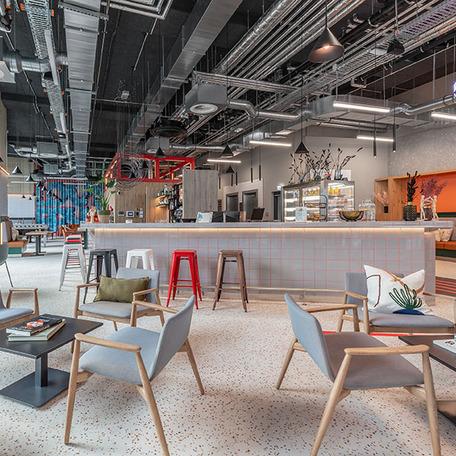 Ein mobliertes Cafe mit einer grossraeumigen Kueche und Theke innerhalb eines Gebaeudes des Gewerbecampus Ovum in Koeln