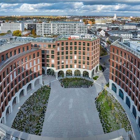 Drohnenaufnahme des Kreisels zwischen der einzelnen Gebaeude des Gewerbecampus Ovum in Koeln mit Logo