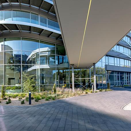 Gebaeude des Erweiterungsbau eines Reiseveranstalters von aussen mit einer gebogenen Glasfront