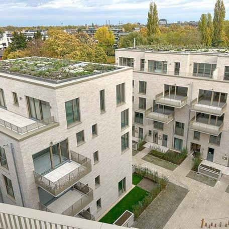 Aufnahme vom Dach von zwei Wohnhaeusern des Rohbaus in Duesseldorf mit aufwendiger hochwendiger Klinkerfassade, Dachbegruenung, Balkoenen, Terrassen, Gartenanlagen, Eingaengen und Gehwegen