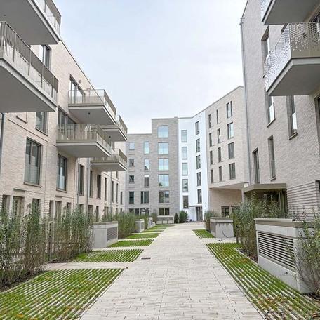 Aufnahme mit Fokus auf den Geweg zwischen den Wohngebaeuden des Rohbaus in Duesseldorf mit aufwendiger hochwendiger Klinkerfassade, Balkoenen, Terrassen und Eingaengen