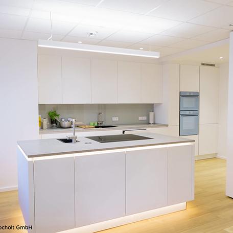 Kueche mit freistehender Theke in weiß und Holzboden der sanierten Gewerbeflaeche in Bocholt