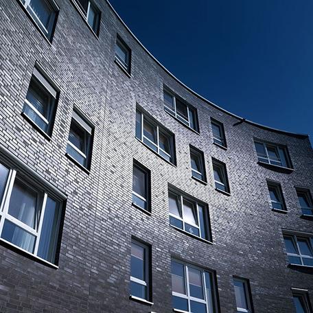 Fokus auf Wölbung des Gebaeude des sozial Senioren Wohn- und Pflegezentrum in Bocholt mit grauer Fassade und Fenstern