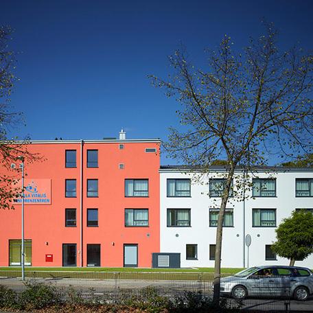 Seitenansicht des Seniorenpflegezentrum in Alsdorf von aussen mit braun-roter und weisser Fassade und des Logos