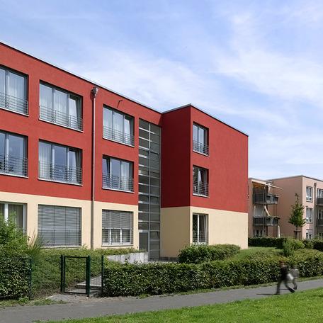 Seniorenzentrum in Duisburg von aussen mit rot beige Fassade und Balkone im Hintergrund 