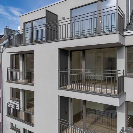 Drohnenaufnahme mit Fokus auf die grauen Balkone und graue Fassade des Bestandsumbau in Duesseldorf Lindenstrasse