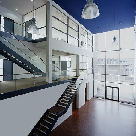 Verwaltungsgebaeude in Bocholt von innen mit Treppen zu Etage eins und zwei mit Holzboden und blauer Decke