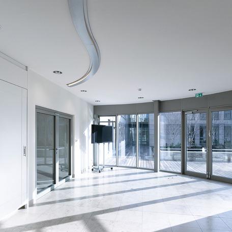 Verwaltungsgebaeude in Duisburg von innen mit grauen Fliesen, weissen Waenden, gewoelbter Fenster Fassade und weissen Waenden