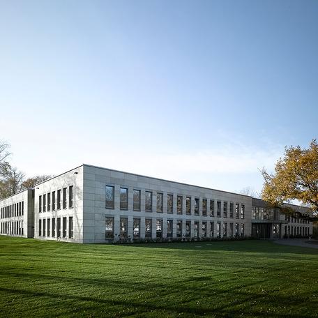 Verwaltungsgebaeude in Duisburg von aussen mit grauer Fassade und gruener Wiese umliegend
