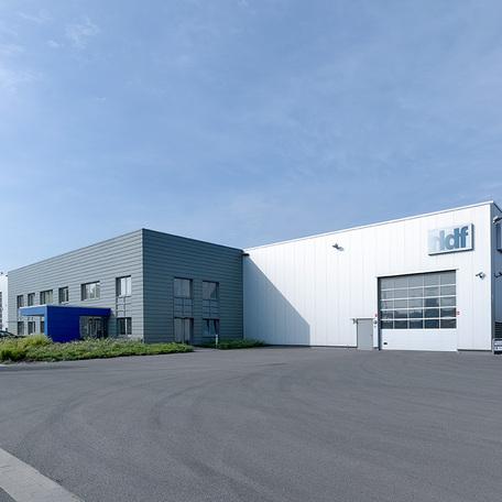 Verwaltungsgebaeude und Produktionshalle in Duisburg  von aussen mit grauer Fassade, Eingang und grossen Hallentor