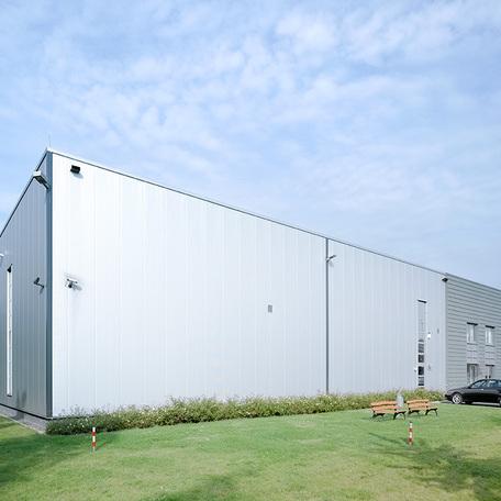 Verwaltungsgebaeude und Produktionshalle in Duisburg von aussen mit grauer Fassade und Baenken