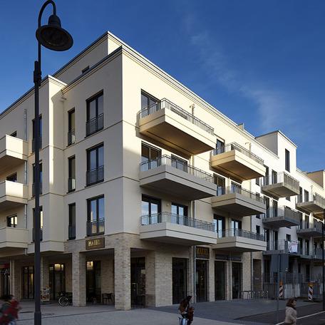 Wohn- und Gewerbekomplex in Bonn von aussen mit beiger Fassade, Ladenlokal und Balkonen