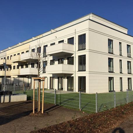 Wohn- und Gewerbekomplex in Bonn von aussen mit beiger Fassade, Balkonen, Garten und Terrassen