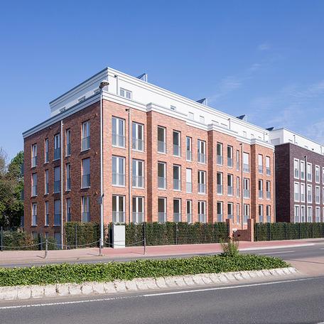 Wohnungsgebaeude in Bocholt am Fluss von aussen mit Klinkerfassade und Strasse davor