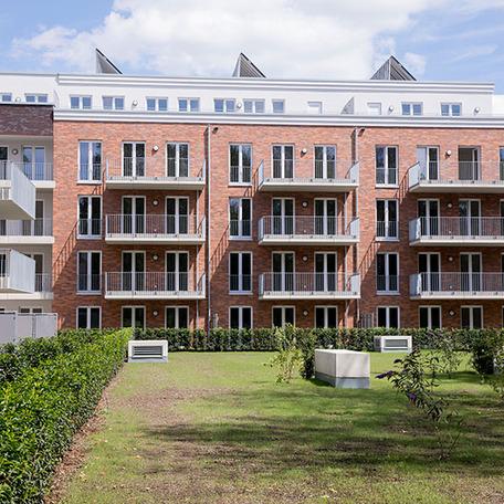 Wohnungsgebaeude in Bocholt am Fluss von aussen mit Klinkerfassade, Balkonen und Wiese