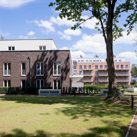 Wohnungsgebaeude in Bocholt am Fluss von aussen mit Klinkerfassade, Balkonen und Wiese