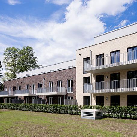 Wohnungsgebaeude in Bocholt am Fluss von aussen mit Klinkerfassade, Balkonen und Wiese