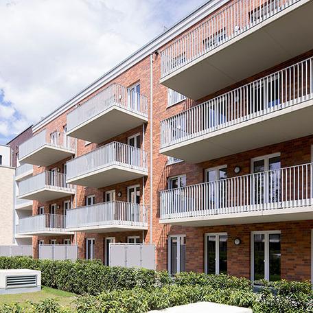 Wohnungsgebaeude in Bocholt am Fluss von aussen mit Fokus auf die Klinkerfassade und Balkonen