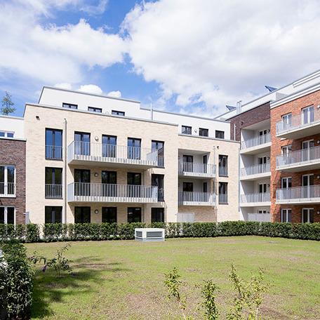 Wohnungsgebaeude in Bocholt am Fluss von aussen mit Klinkerfassade, Balkonen und Wiese
