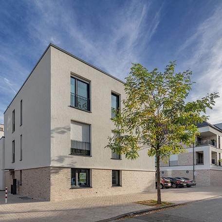 Wohnungen des Wohnquatiers in Moers mit weisser Fassade und Parkplatz