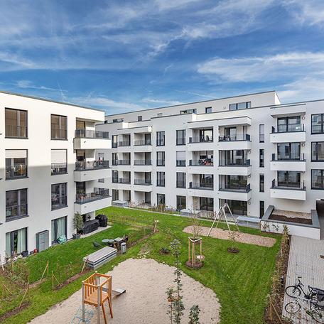 Wohnungen des Wohnquatiers in Moers mit weisser Fassade, Balkonen, Terrassen und Spielplatz