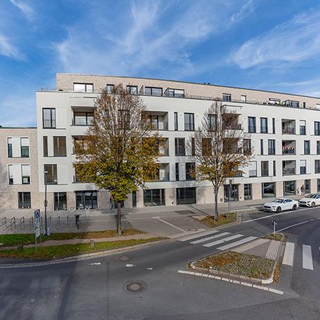 Wohnungen des Wohnquatiers in Moers mit beige, grauer Fassade, Dachterrassen und Strasse mit Zebrastreifen