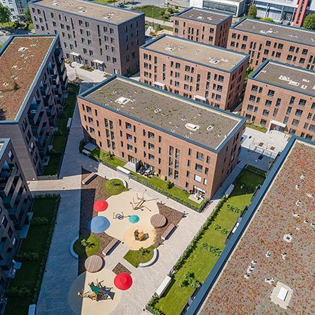 Drohnenansicht aller Gebaeude des Wohnquatiers in Muenster mit Spielplatz und Gaerten