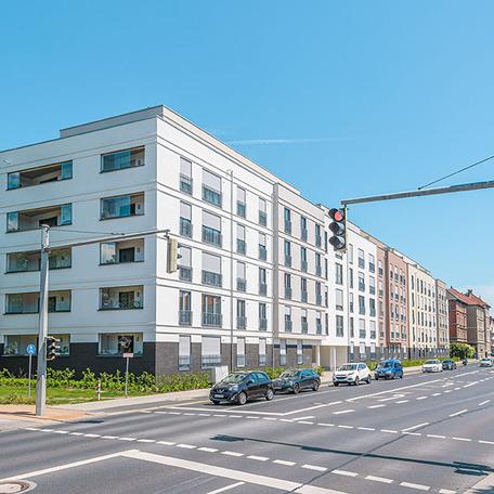 Haeuserreihen des Wohnquatiers in Braunschweig mit heller Fassade, Balkonen und Anbindung zur Strasse