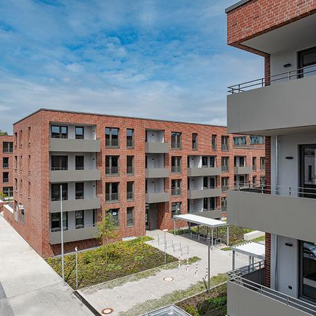 Gebaeudereihen des Wohnquatier York in Muenster mit Klinkerfassade, Balkonen, Eingaengen, Fahrradstaendern und Gehwegen