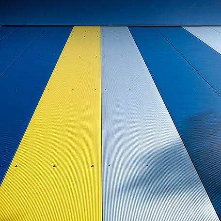 Fokus auf die gelb blauen Streifen an der Fassade von aussen des Zentrallagers in Luettow-Valluhn