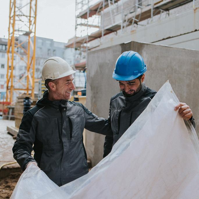 mitarbeiter_mit_bauplan_ausbilder_auszubildender_schmeing_baustelle
