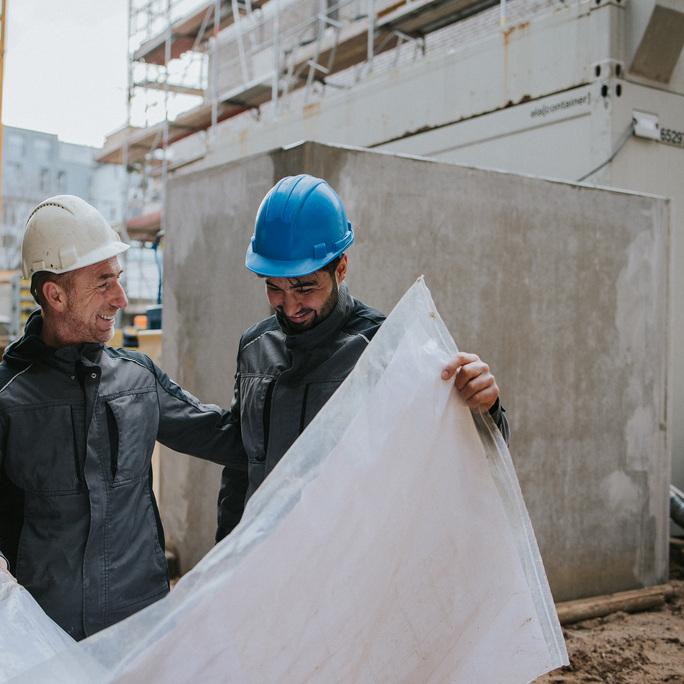 mitarbeiter_mit_bauplan_ausbilder_auszubildender_schmeing_baustelle