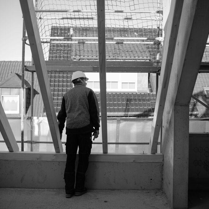 mitarbeiter_auf_baustelle_schaut_in_ferne_schmeing mitarbeiter_auf_baustelle_schaut_in_ferne_schmeing