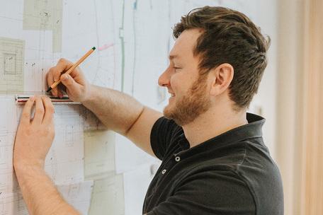 bauleiter_bei_der_arbeit_mit_bauplaenen_im_buero_schmeing