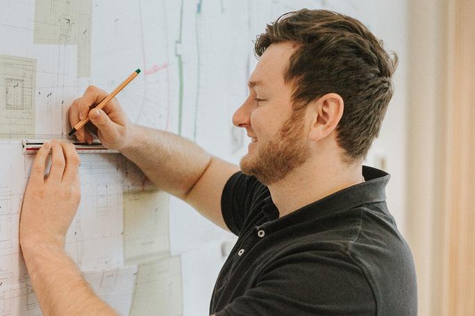 bauleiter_bei_der_arbeit_mit_bauplaenen_im_buero_schmeing
